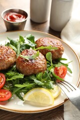 Delicious patties with greens, tomatoes and ketchup on wooden table, closeup