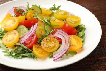 Fresh salad with yellow tomatoes on wooden table, closeup