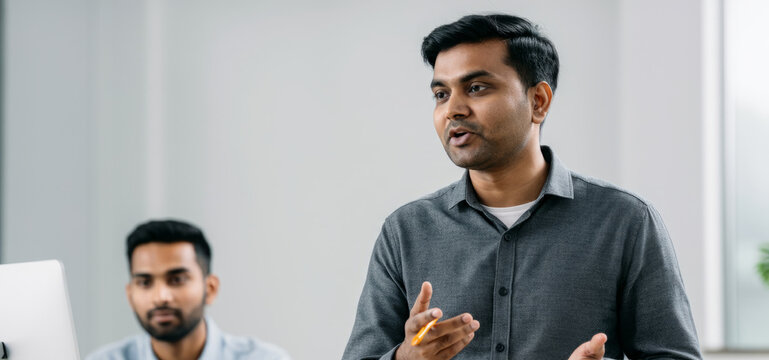 Confident young asian male presenting in office setting