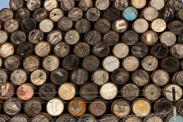 Stacked wooden barrels aged by time, storing fine whisky, wine, or craft beer. Rich textures, warm tones, and artisanal charm captured in close-ups of ancient and noble barriques