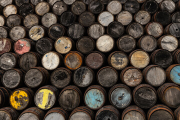 Stacked wooden barrels aged by time, storing fine whisky, wine, or craft beer. Rich textures, warm tones, and artisanal charm captured in close-ups of ancient and noble barriques