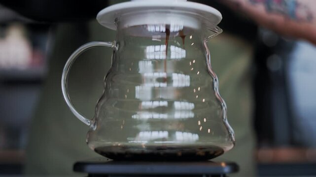 This close-up still emphasizes each drop of coffee as it travels through the syphon filter into the waiting glass chamber, ready for infusion
