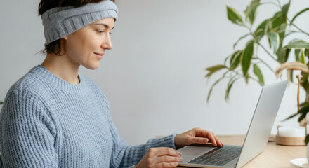 Naklejka premium Caucasian female adult working on laptop in cozy home office setting