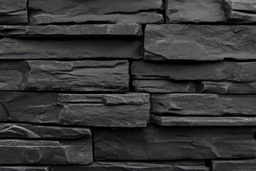 Dark grey stone wall texture. Close-up view of interlocking rectangular stone panels