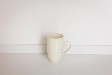 Elegant White Ceramic Mug on Reflective Surface Against White Background