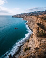 Breathtaking Aerial View of Cliffside Coastline with Helicopter Over Azure Ocean Waves
