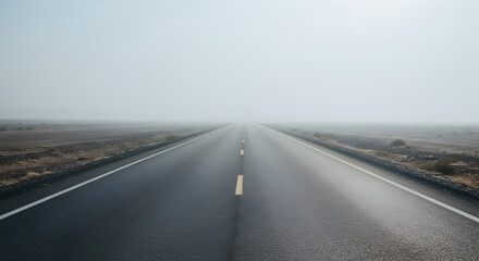 Fototapeta premium Endless Road Disappearing into Thick Fog in a Mysterious Atmospheric Scene