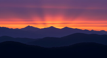 Fototapeta premium Dramatic Mountain Range Silhouette Against Vivid Sunset And Vibrant Sky