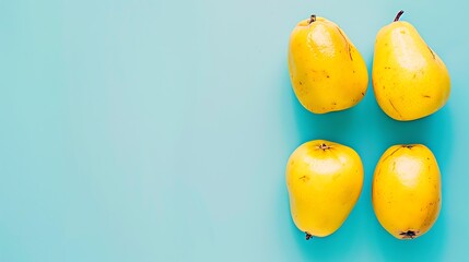 Minimalist composition of bright yellow quince fruits on a serene blue backdrop