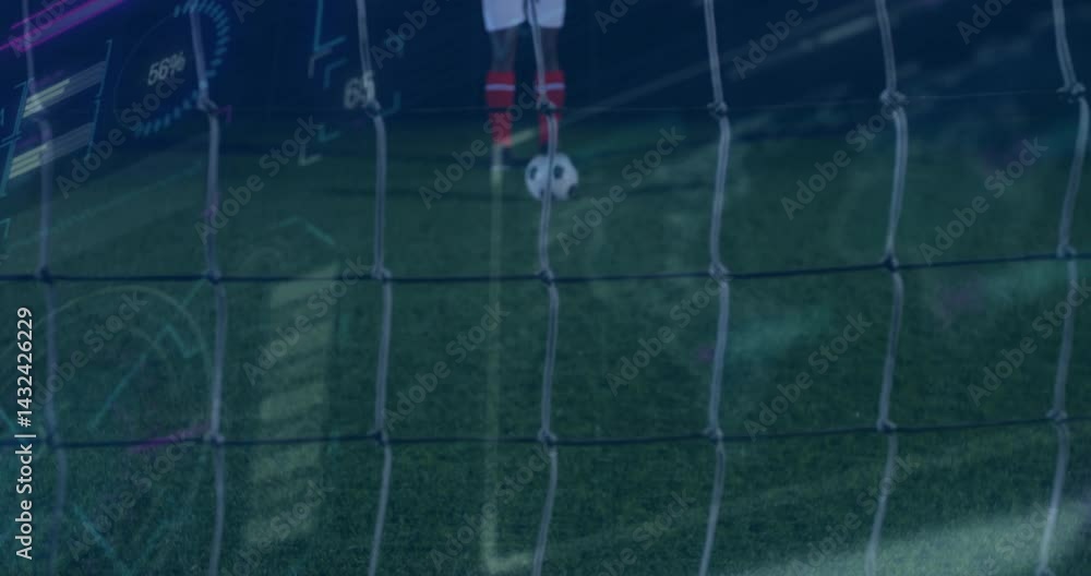 Poster soccer player standing behind net, displaying tech performance analytics overlays on turf at night