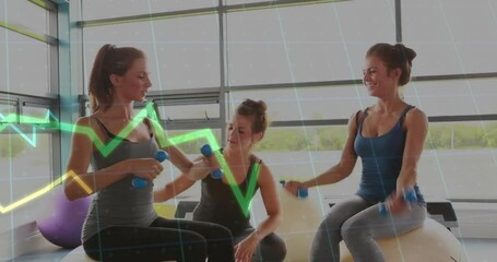 Three women exercising on stability balls in gym, lifting blue dumbbells with floating health chart - Powered by Adobe