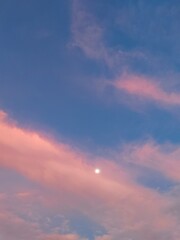 sunset sky with clouds and distance moon