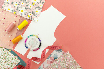Drawing and fabric for sewing clothes. The process of sewing clothes on a pink background....