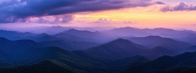 Obraz premium Serene mountain landscape at sunset, showcasing layered hills and vibrant sky colors.