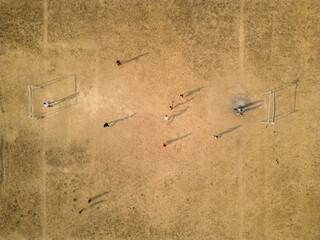 Drone aerial view of a football field in rural Thailand. Local children play football in the evening...