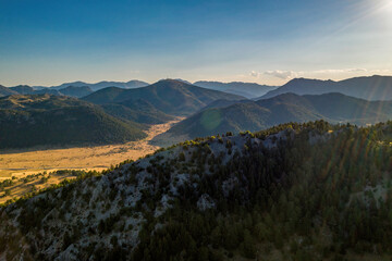 Obraz premium Aerial view of mountains covered with dense trees in a misty weather. Natural landscape photo.