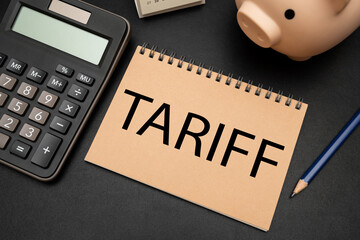 TARIFF text on Notebook with calculator and office supplies. Import Trade Tariffs increase concept....