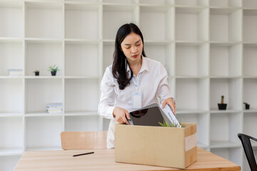 Business woman with box cardboard packing personal items after losing jobs. asian business woman...