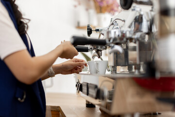 Young caucasian asian woman working with cash box in coffee shop behind the counter. Female worker, barista, waitress, manager, administrator checking bill order on digital cash register.

