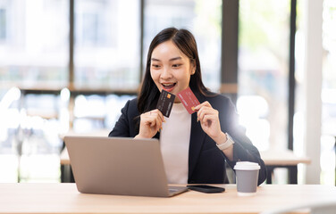 Fototapeta premium Transfer money online business asian woman using bank payment card. Hands input credit card data using phone and laptop. 