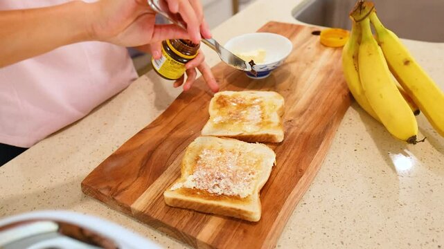 Spreading Vegemite on Toast in a Bright Kitchen