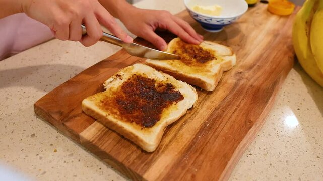 Spreading Vegemite on Toast in a Kitchen Setting