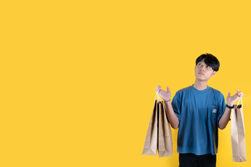 A man with some of brown shopping bag while looking up