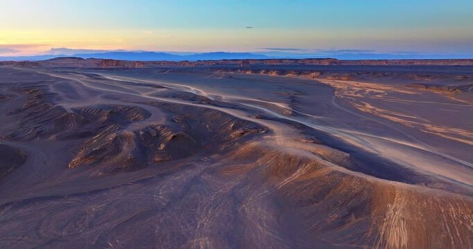 Aerial shot of the spectacular and desolate yardang landform desert landscape at sunset in Xinjiang, China.