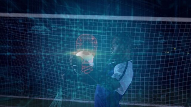 Goalkeeper holding glowing soccer ball in night stadium, showing sports tech with neon data lines - Powered by Adobe