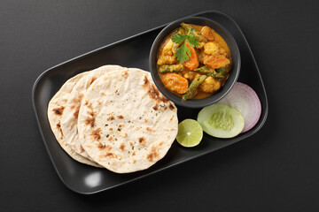 Indian traditional cuisine food mix veg curry made with carrots potatoes cauliflower beans and bell peppers with tandoori roti