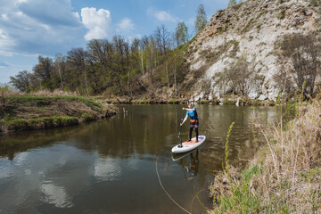 Experience the calming joy and serenity of paddleboarding on a tranquil river, completely surrounded by natures breathtaking beauty and the rich wildlife in a peaceful and untouched wilderness