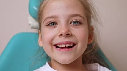 Little girl performs articulation exercises for mouth, concept of speech disorders, correction. Dentist, doctor examines oral cavity of small patient, length of frenum of the tongue. Motion footage - Powered by Adobe
