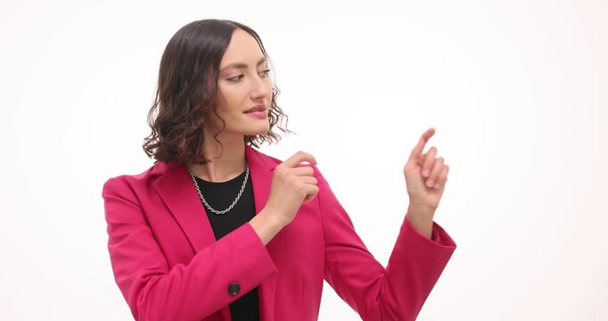 Woman points with index fingers towards side in turn with focused and directing expression. Posture and gaze suggest specific direction and object