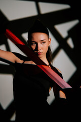 Woman performs rhythmic gymnastics with ribbon in artistic indoor setting during competition