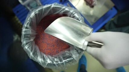 worker dispensing process of medicine drug powder in a pharmaceutical factory. weighing Active pharma ingredients raw material and dispensing. transferring powder from bulk containers to smaller packs