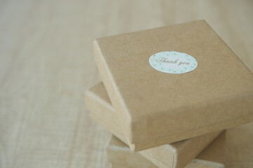 Gift boxes stacked on a wooden surface with a thank you label