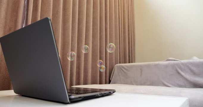Soap bubbles emerge from screen of laptop, symbolizing fleeting nature of user reactions on online content in modern digital world. Bubbles float briefly before disappearing