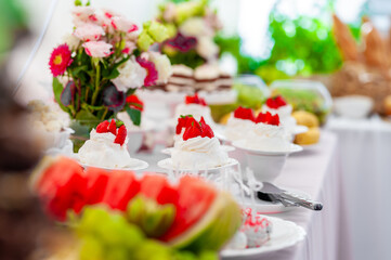 Delightful Wedding Table Spread With Desserts, Flowers, and Fresh Fruit in Natural Light