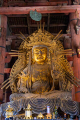 Golden Buddha statue radiates serenity in a serene temple setting in Japan, surrounded by intricate wooden architecture and soft candlelight