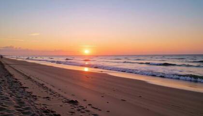 Obraz premium Sunset over a serene beach with gentle waves lapping shore.
