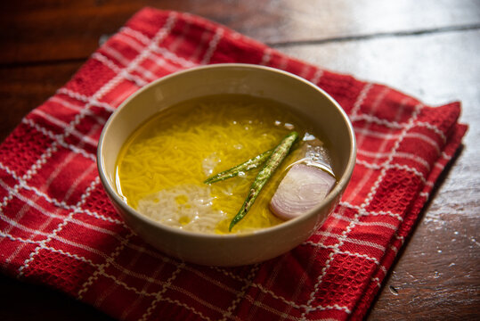 Panta bhat or pakhala or fermented rice soup with water, green chillies and onion in a bowl. Staple food in Eastern India. Close up, selective focus.	