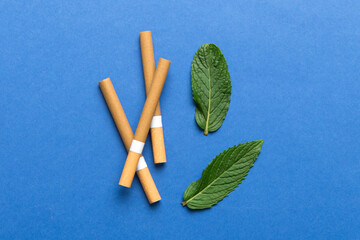 Menthol cigarettes and fresh mint leaves on colored background, Many cigarettes stacked together top view flat lay
