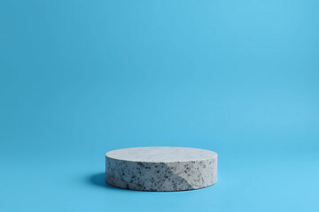 Flat granite pedestal and white flowers on blue background. Stone stand for natural design concept. Horizontal image, center composition, hard light, front view