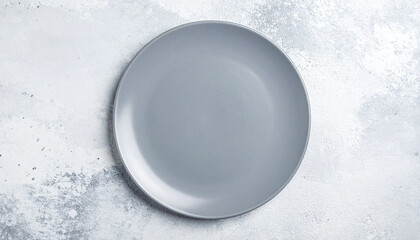 Empty round gray plate on light textured stone background. Ceramic tableware. Top view.