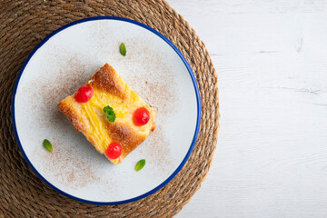 Coca San Juan, a traditional Catalan dessert similar to brioche with pastry cream and candied fruit. Top view table.