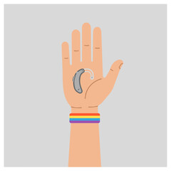 Fototapeta premium Hand with Hearing Aid and Rainbow Bracelet Against Gray Background 