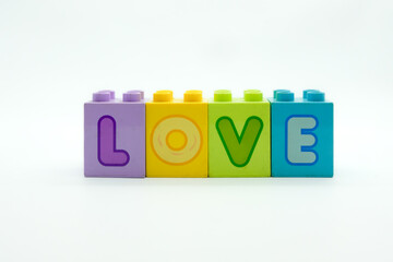 Colorful stacking LOVE alphabet on building blocks isolated on a white background. Concept Love for family, parent, couple, happiness, valentine, etc