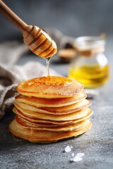 Golden Pancakes Stacked High Drizzled with Honey from Wooden Dipper on a Neutral Background Creates a Warm and Inviting Breakfast Scene with a Focus on Delicious Texture