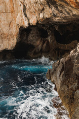 Sea cave with turquoise water. Moody landscape. Sardinian cave. Copy space.