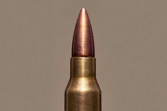 Close up of .223 Remington bullet cartridge tip on brown background
